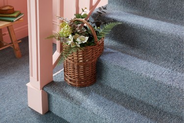 A rustic hallway area with navy wool carpet, blush panelled walls and basket weave accessories