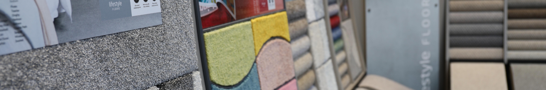 A close up shot of several carpet stands, which includes coloured and grey ranges.