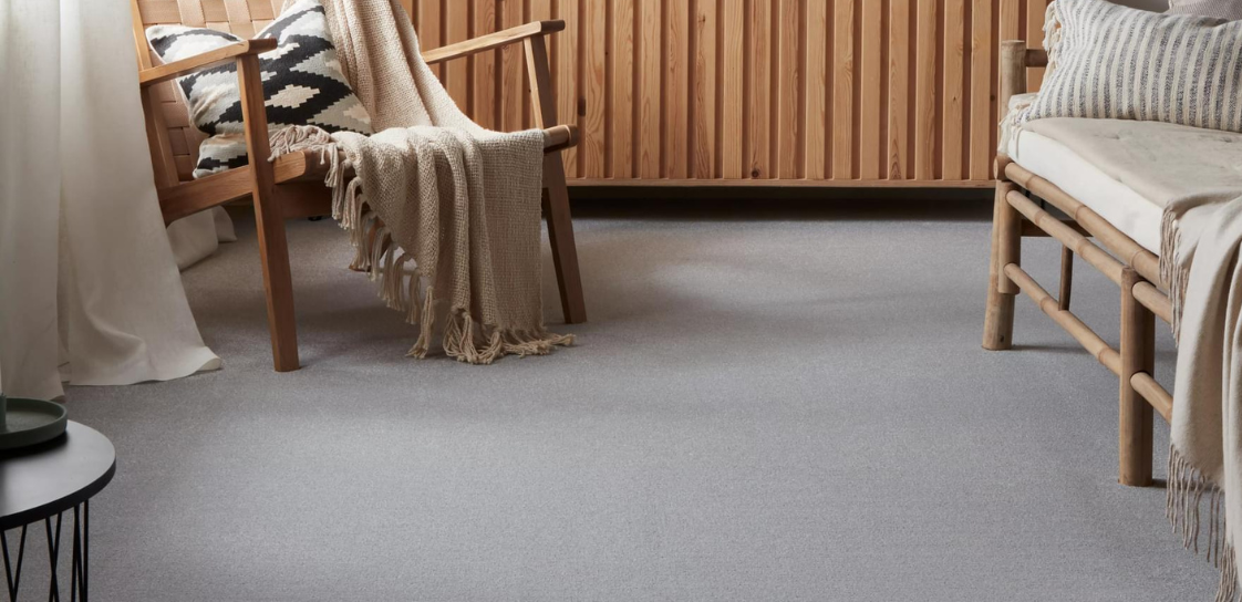 A natural inspired seating area with wooden chairs & accessories & light grey carpet