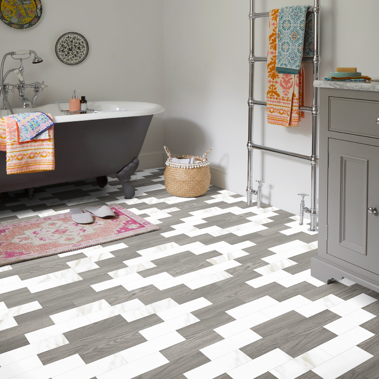 A patterned grey and white LVT floors in a grey bathroom with pink and orange accents