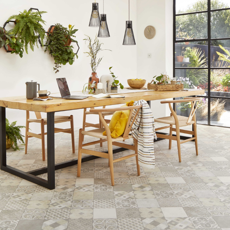 A wooden table and chairs are placed on a tile effect vinyl floor