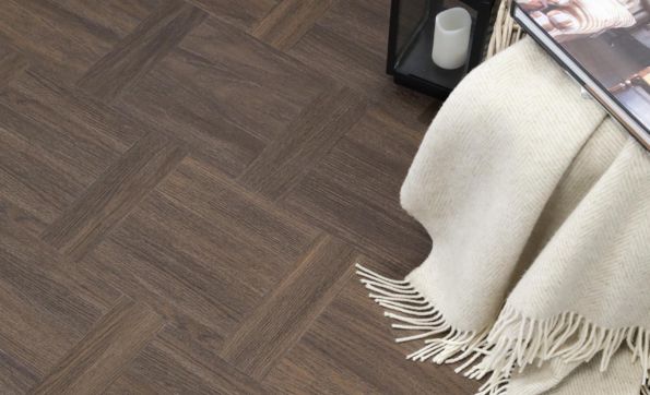 Dark wood parquet LVT with a cream throw and black lantern
